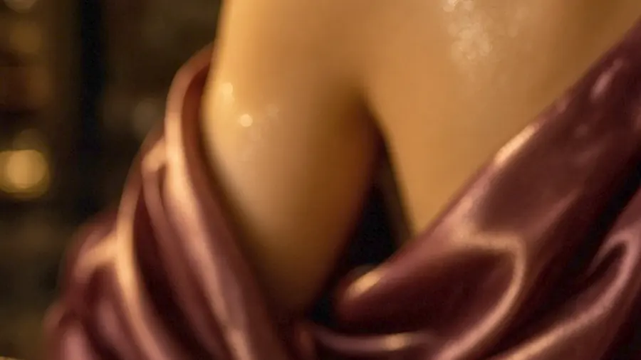 Erotic massage near me - price card on a counter in a candlelit room, silk and skin behind