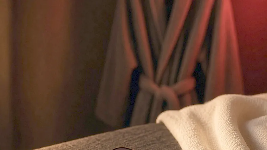 Nude massage near me - venue listing open on a phone beside draped silk and bare skin