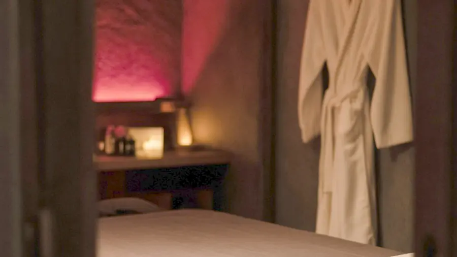 Nude massage near me - oiled bare back on a massage table in candlelight