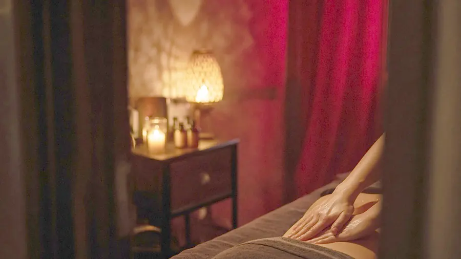 Sensual massage near me - oiled bare back on a massage table in candlelight